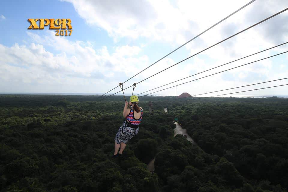 Kvinna åker zipline över skog