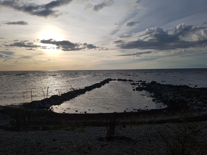 Solnedgång över havet vd stenstranden