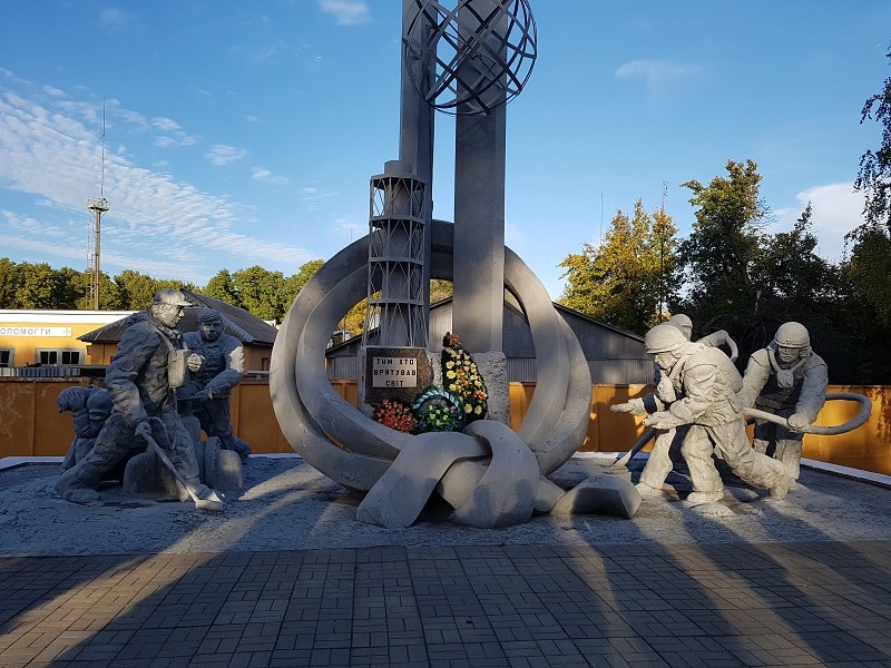 Monument i betong av släckande brandmän