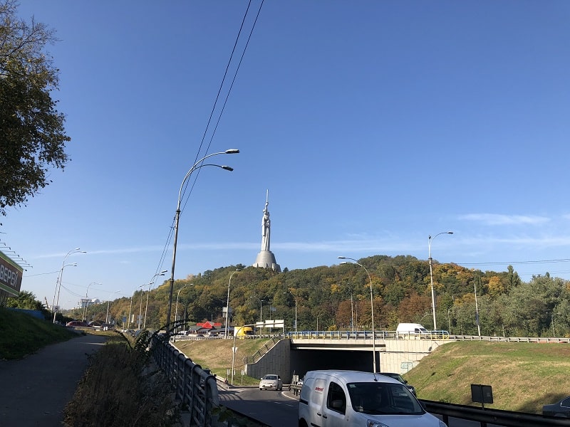 Hög staty i fjärran över väg och skog