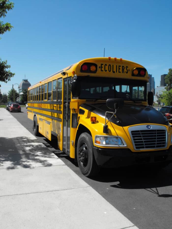 Gul klassisk skolbuss parkerad på gata