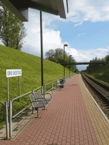 Tågstation med några sittplatser vid grön sluttning