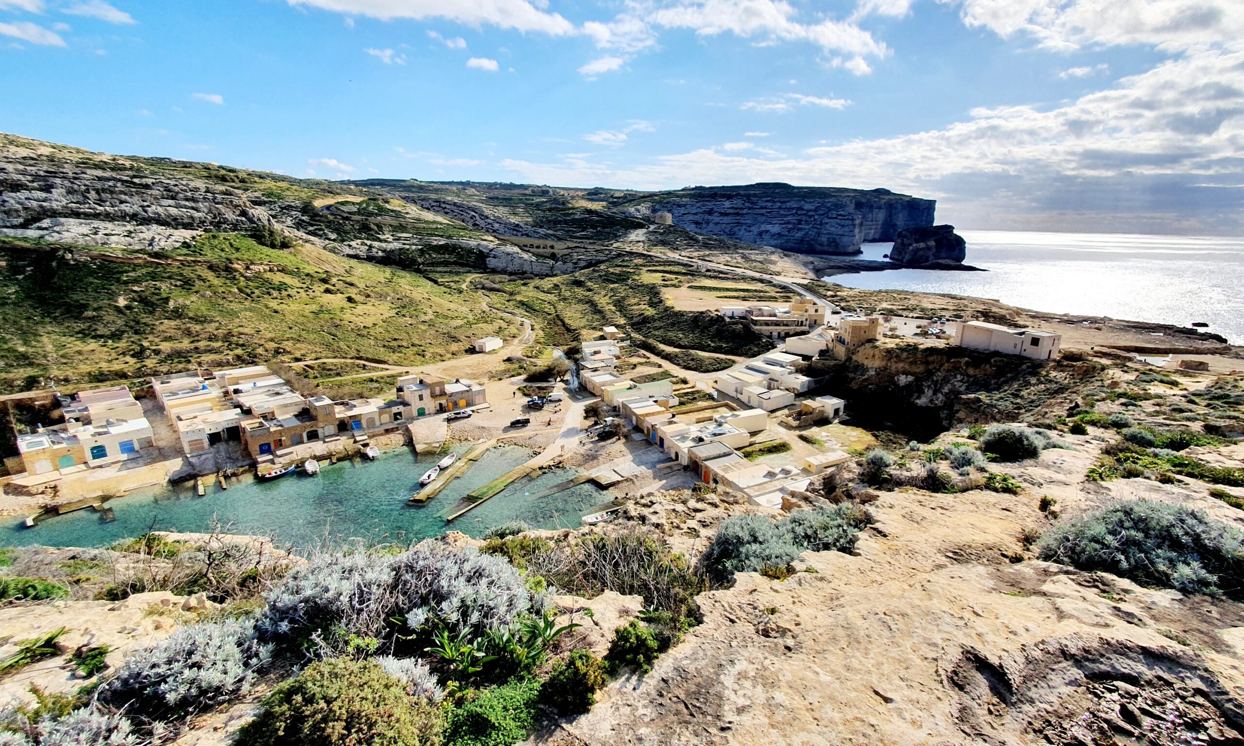 Utsikt över landskap med inlandssjö, berg och hav med höga klippor