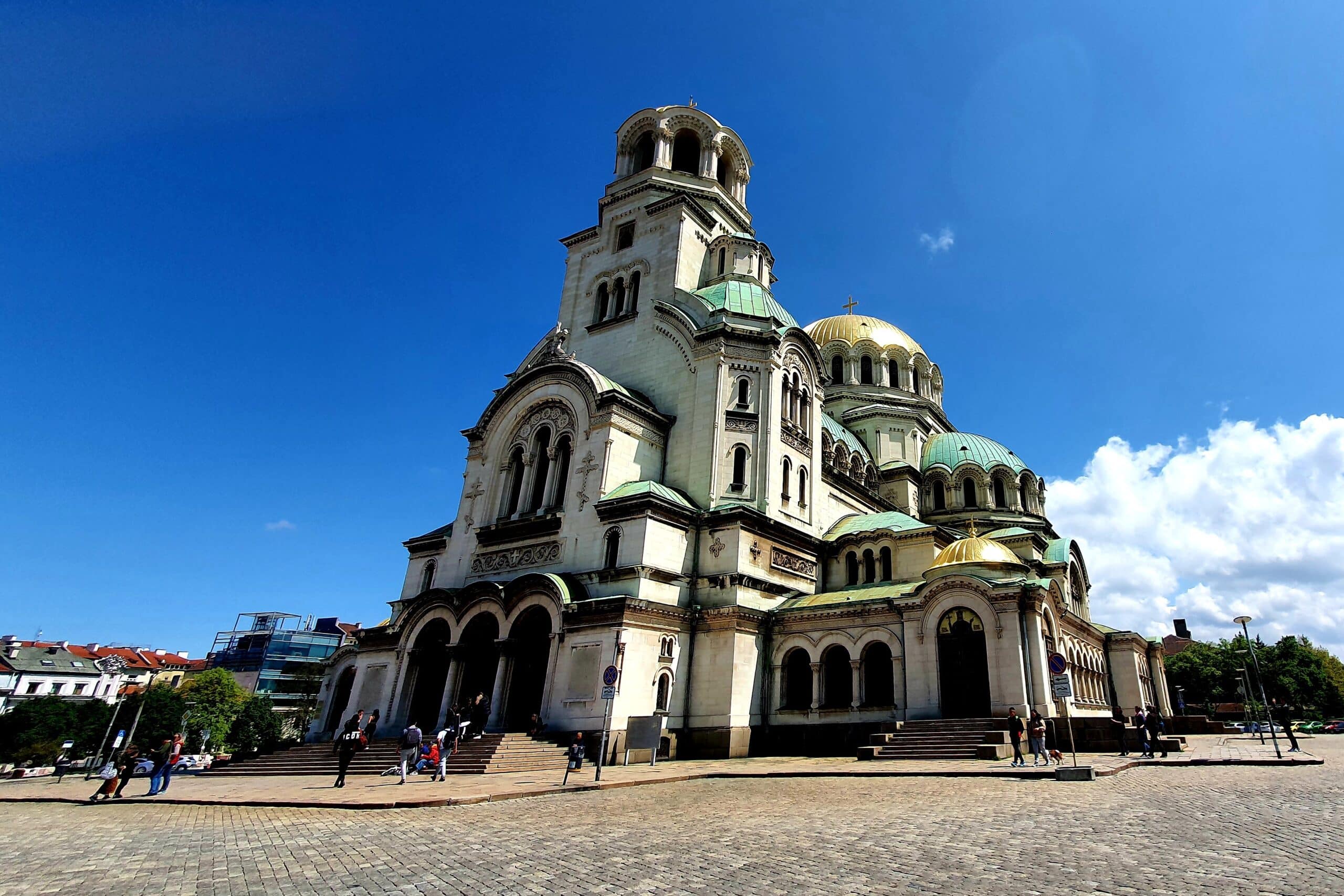 Vit mäktig katedral med grönt tak och guldkupoler